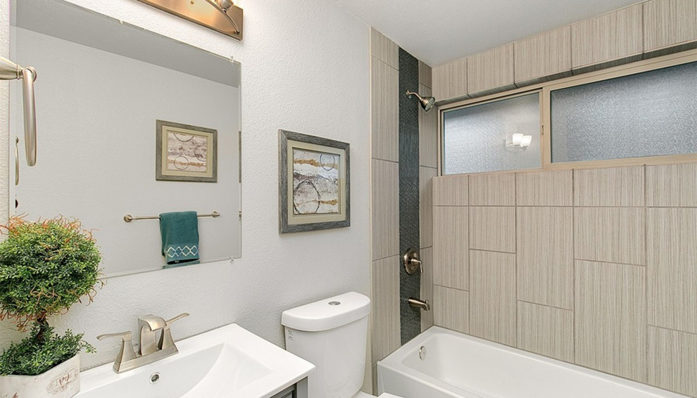 Small transitional kids' gray tile and porcelain tile ceramic tile alcove shower photo in Seattle with flat-panel cabinets, gray cabinets, a one-piece toilet, gray walls, an integrated sink and solid surface countertops