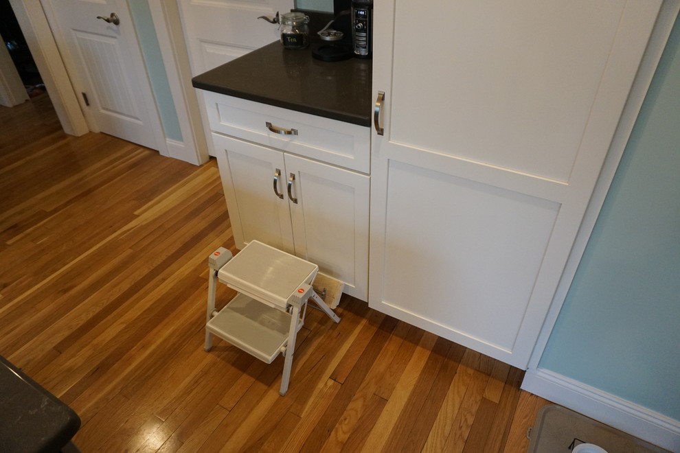 Eat-in kitchen - mid-sized transitional u-shaped medium tone wood floor eat-in kitchen idea in Boston with an undermount sink, shaker cabinets, gray cabinets, quartz countertops, black backsplash, stainless steel appliances and an island