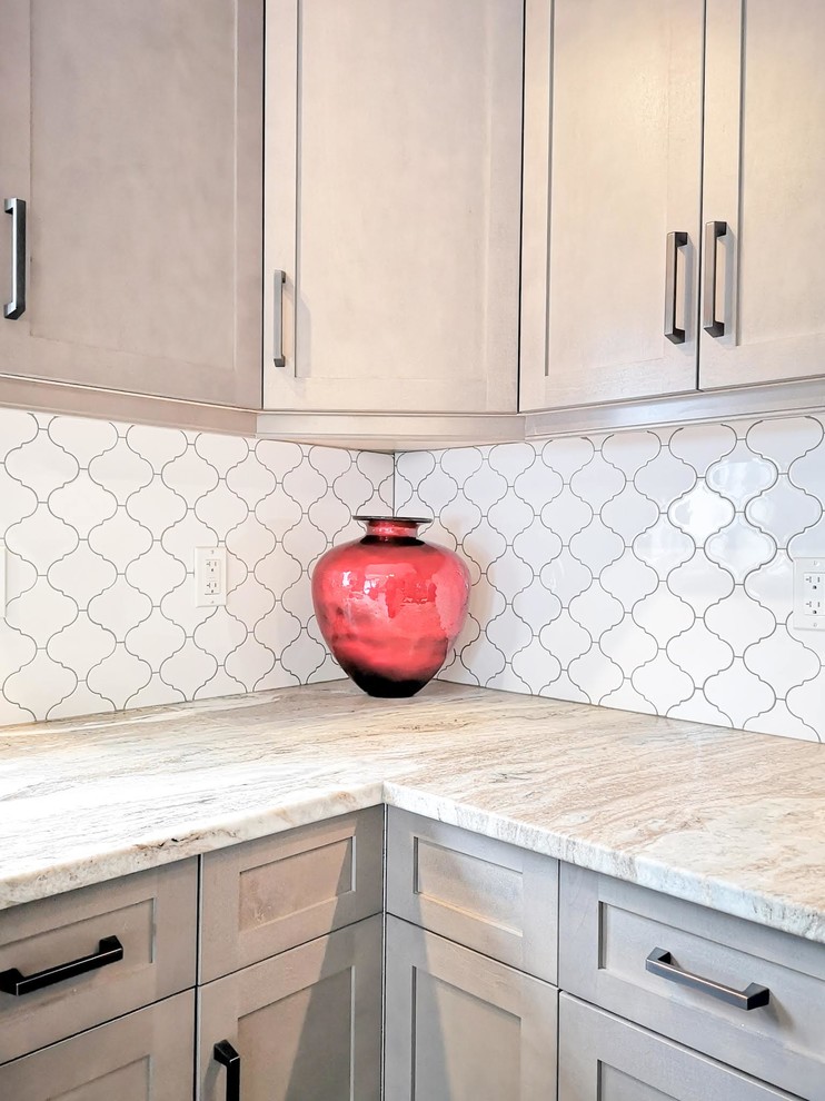 Mid-sized transitional l-shaped medium tone wood floor and brown floor open concept kitchen photo in Toronto with an undermount sink, shaker cabinets, light wood cabinets, granite countertops, white backsplash, porcelain backsplash, stainless steel appliances, an island and beige countertops