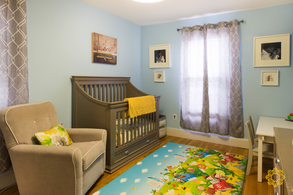Photo of a mid-sized transitional gender-neutral nursery in New York with blue walls and medium hardwood floors.