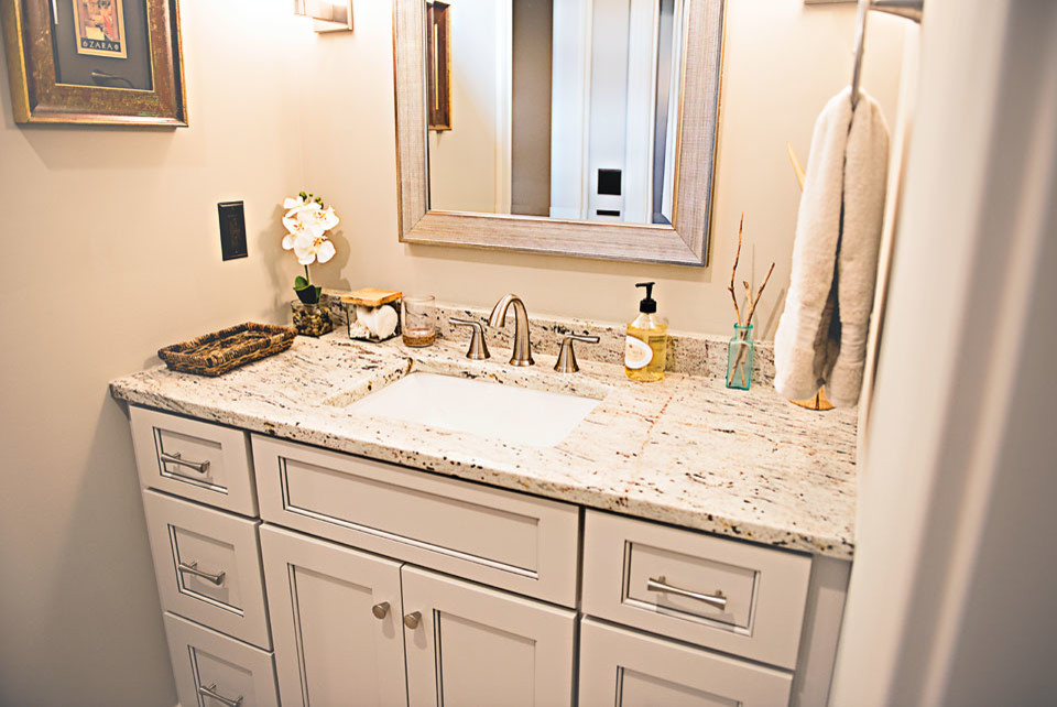 This is an example of a mid-sized transitional powder room in Nashville with recessed-panel cabinets, grey cabinets, an undermount sink, granite benchtops and multi-coloured benchtops.