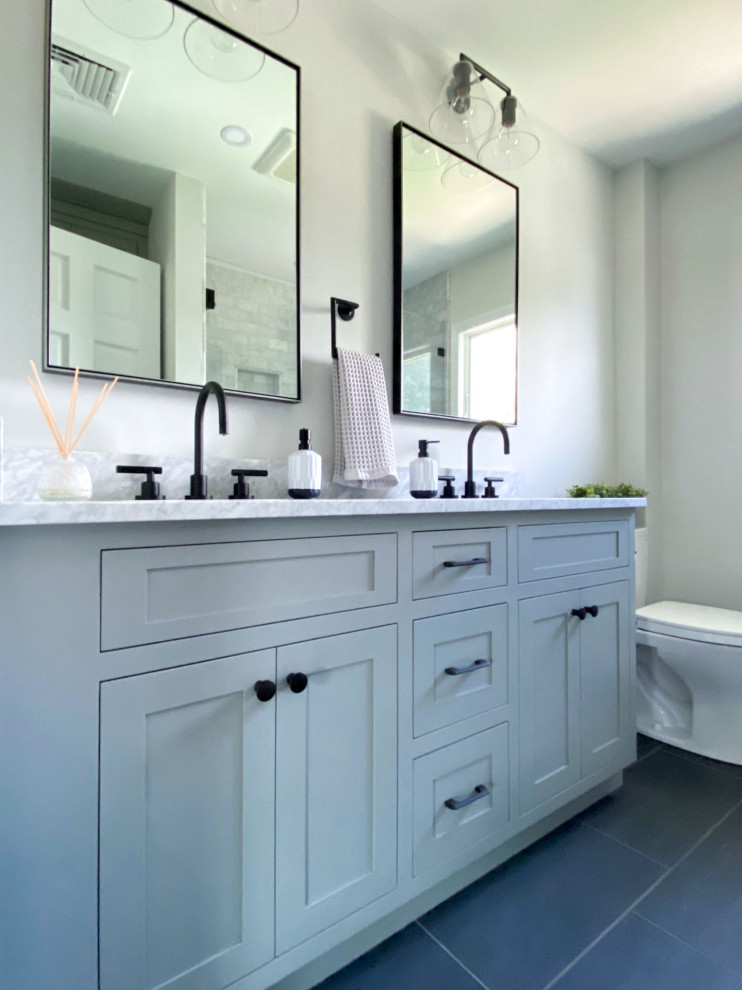 Inspiration for a mid-sized transitional master bathroom in Boston with shaker cabinets, grey cabinets, an alcove shower, a two-piece toilet, gray tile, marble, grey walls, porcelain floors, an undermount sink, marble benchtops, black floor, a hinged shower door, grey benchtops, a shower seat, a double vanity and a built-in vanity.
