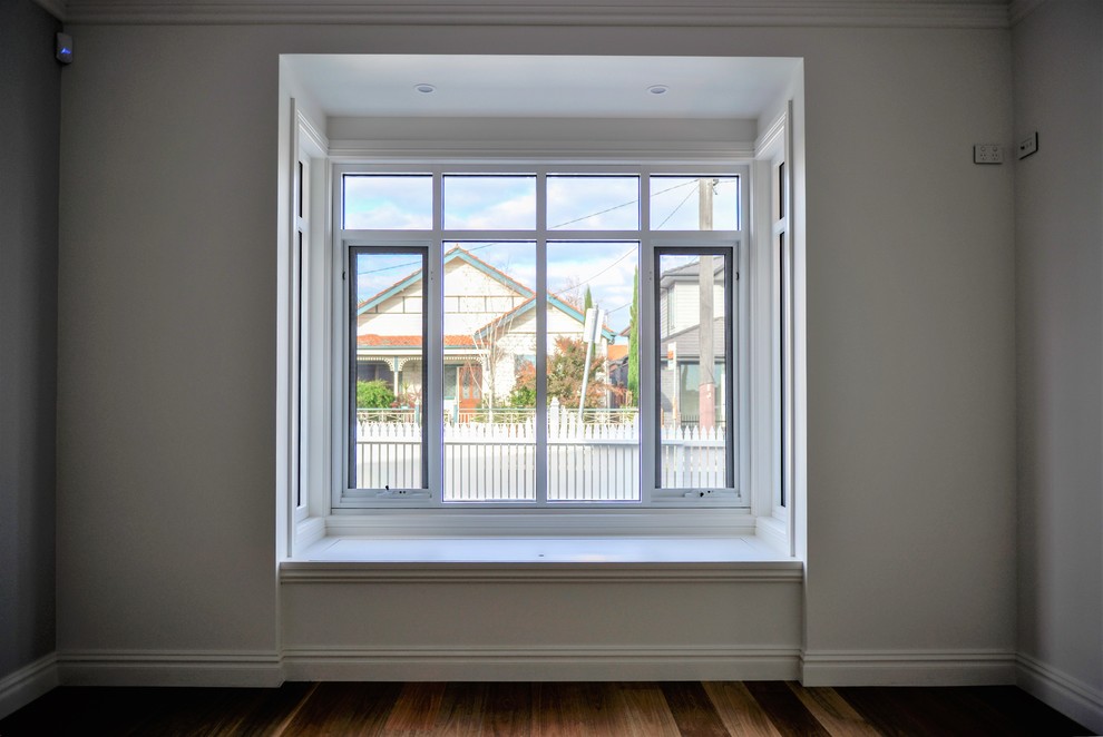 Design ideas for a mid-sized traditional master bedroom in Melbourne with white walls and medium hardwood floors.