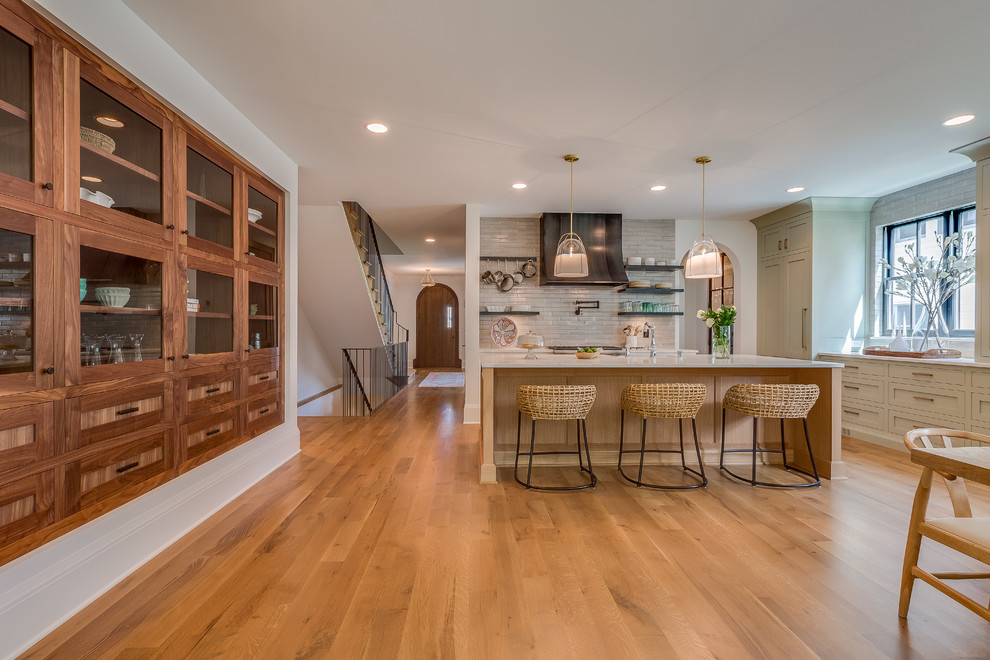 Photo of a transitional l-shaped eat-in kitchen in Minneapolis with shaker cabinets, grey cabinets, panelled appliances, medium hardwood floors, with island, brown floor and white benchtop.