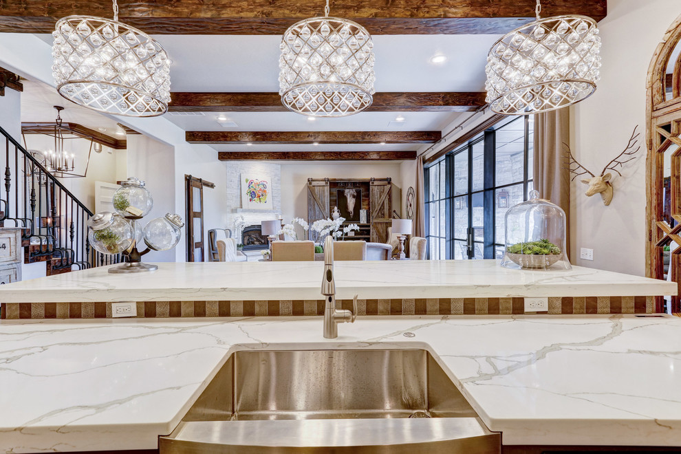 Transitional single-wall open concept kitchen photo in Orange County with a farmhouse sink, raised-panel cabinets, white cabinets, marble countertops, multicolored backsplash, stainless steel appliances and an island