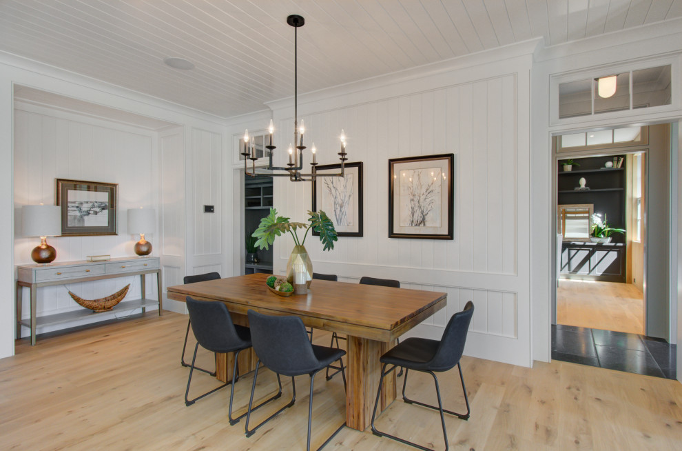 Photo of a large beach style open plan dining in Charleston with light hardwood floors, timber and planked wall panelling.