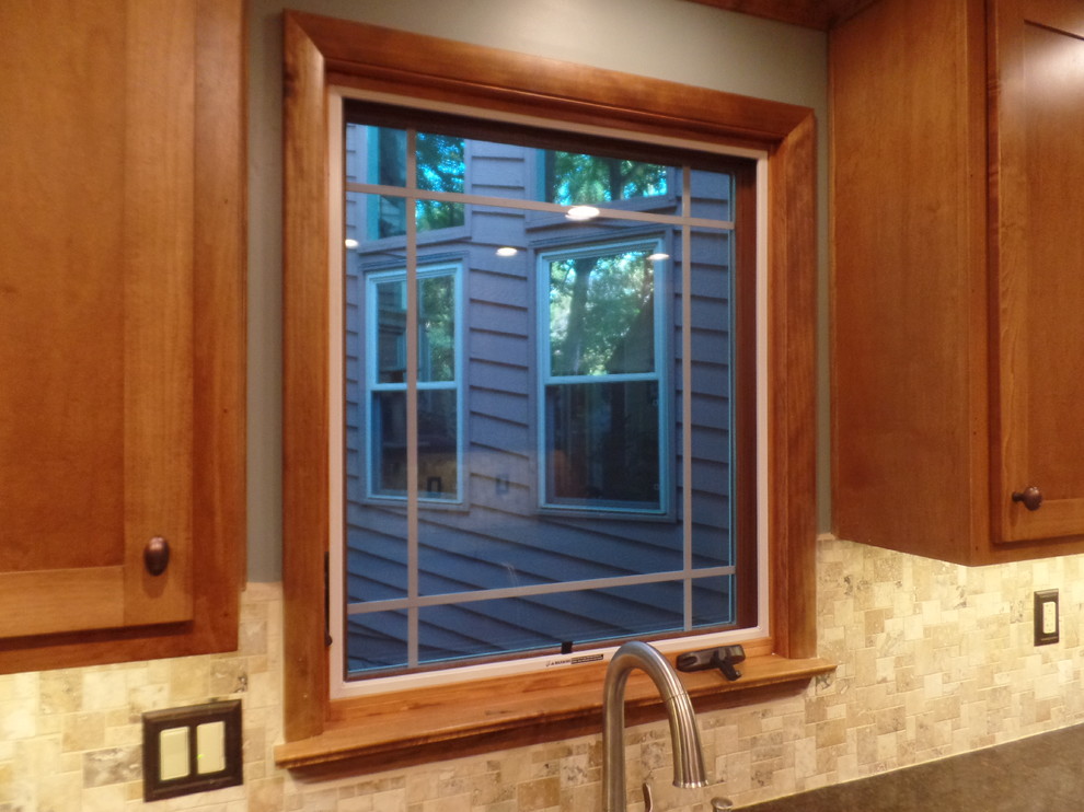 Inspiration for a mid-sized transitional galley home design remodel with an undermount sink, shaker cabinets, medium tone wood cabinets, quartz countertops, multicolored backsplash, travertine backsplash, colored appliances and no island