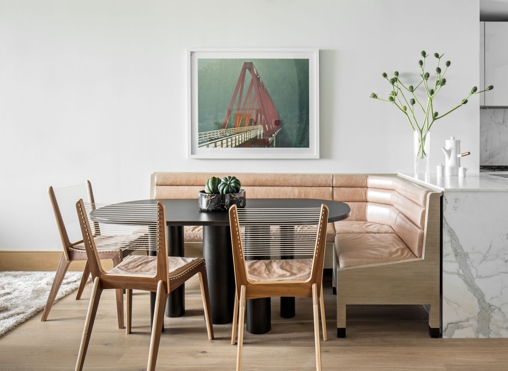 Contemporary open plan dining in New York with white walls, light hardwood floors and beige floor.