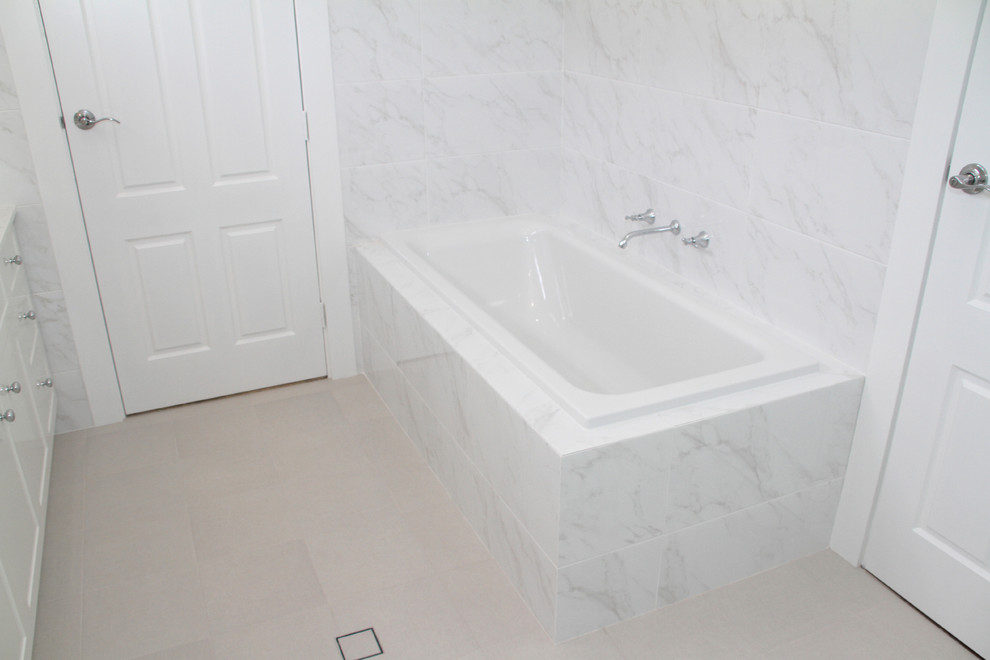 This is an example of a traditional master bathroom in Perth with shaker cabinets, white cabinets, a drop-in tub, a one-piece toilet, white tile, an undermount sink, engineered quartz benchtops and a hinged shower door.