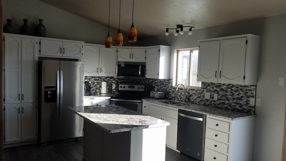 Mid-sized transitional l-shaped dark wood floor and brown floor enclosed kitchen photo with a double-bowl sink, recessed-panel cabinets, white cabinets, granite countertops, multicolored backsplash, mosaic tile backsplash, stainless steel appliances, an island and gray countertops