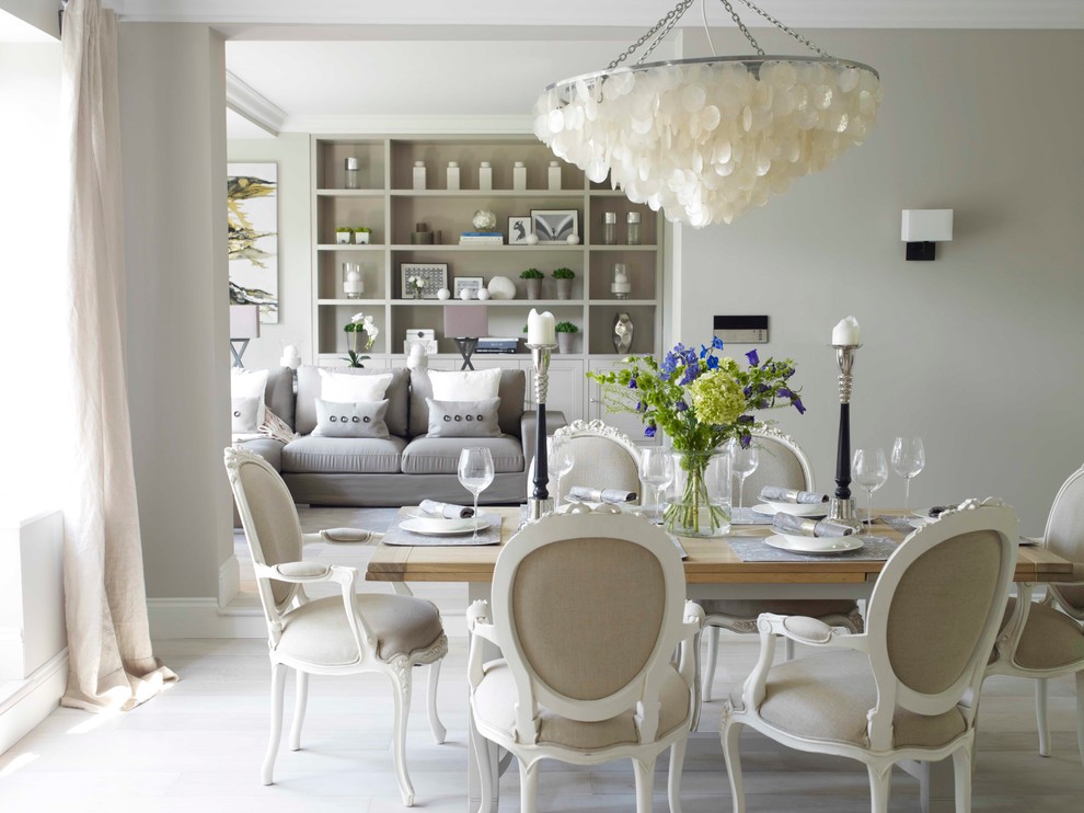 Photo of a mid-sized transitional open plan dining in London with beige walls, light hardwood floors and white floor.