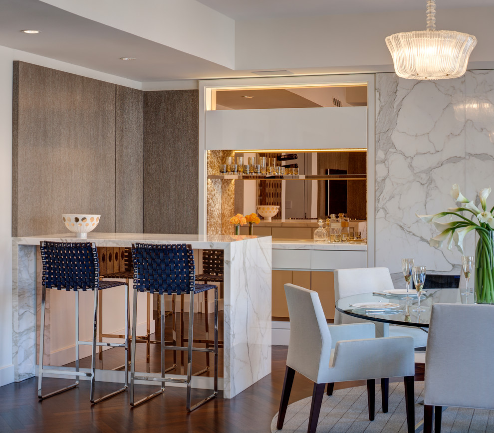 Photo of a small contemporary seated home bar in New York with flat-panel cabinets, mirror splashback, dark hardwood floors and white cabinets.