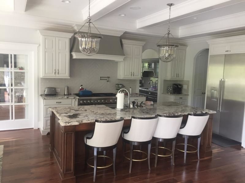 Inspiration for a transitional brown floor kitchen remodel with a drop-in sink, granite countertops, subway tile backsplash, stainless steel appliances and an island