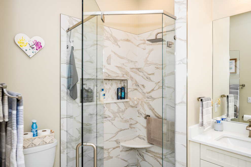 Photo of a small contemporary ensuite bathroom in Tampa with white cabinets, a corner shower, a one-piece toilet, beige walls, a built-in sink, a hinged door, white worktops, a wall niche, double sinks and a built in vanity unit.