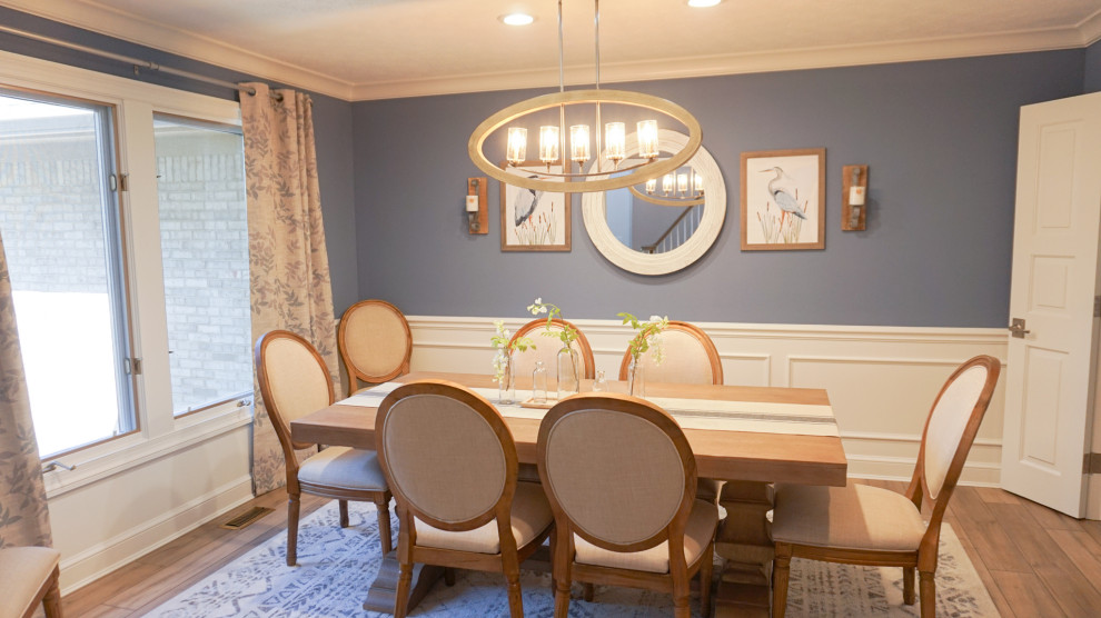 Идея дизайна: отдельная столовая с синими стенами, полом из ламината и панелями на стенах