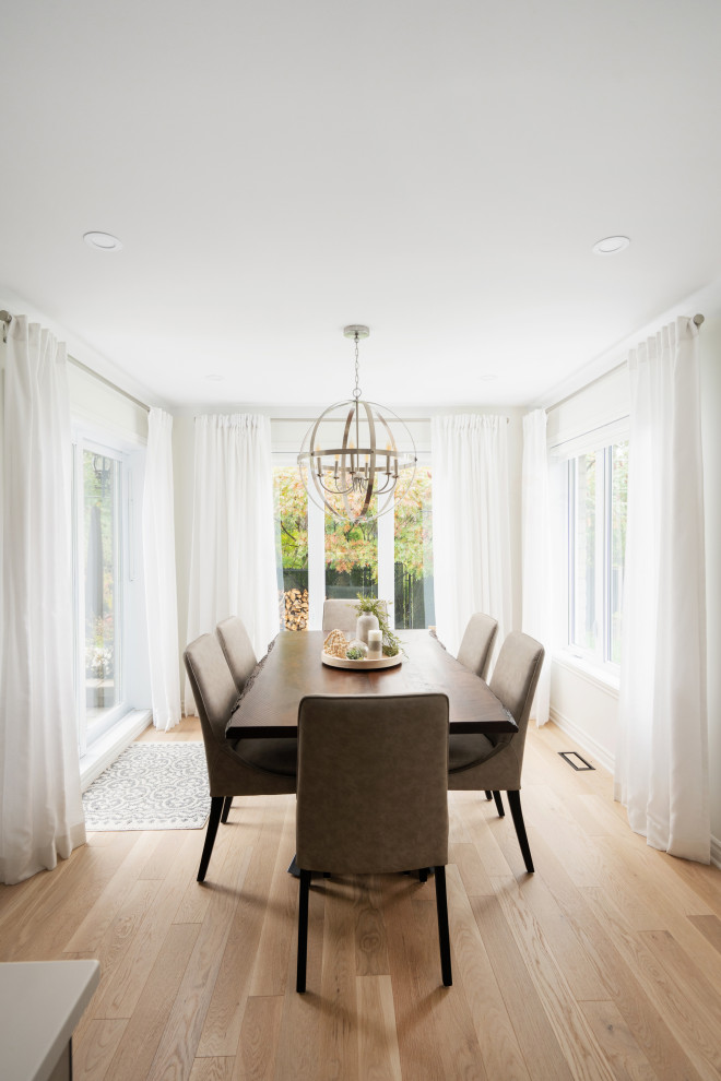 Aménagement d'une salle à manger ouverte sur la cuisine classique de taille moyenne avec un mur blanc, parquet clair et un sol marron.
