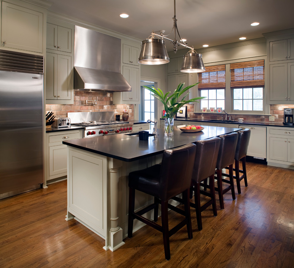 Inspiration for a traditional l-shaped kitchen in New Orleans with recessed-panel cabinets, white cabinets, stainless steel appliances, with island and dark hardwood floors.