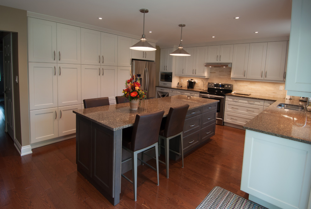 Enclosed kitchen - large transitional u-shaped medium tone wood floor enclosed kitchen idea in Toronto with a double-bowl sink, shaker cabinets, white cabinets, granite countertops, beige backsplash, ceramic backsplash, stainless steel appliances and an island