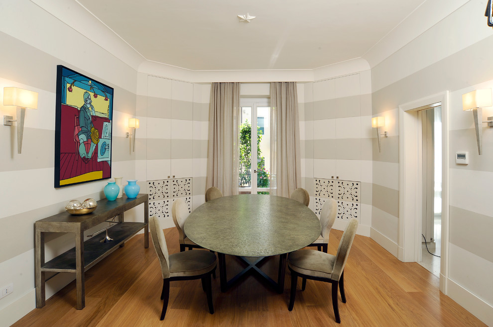 This is an example of an expansive contemporary separate dining room in Milan with beige walls and medium hardwood floors.