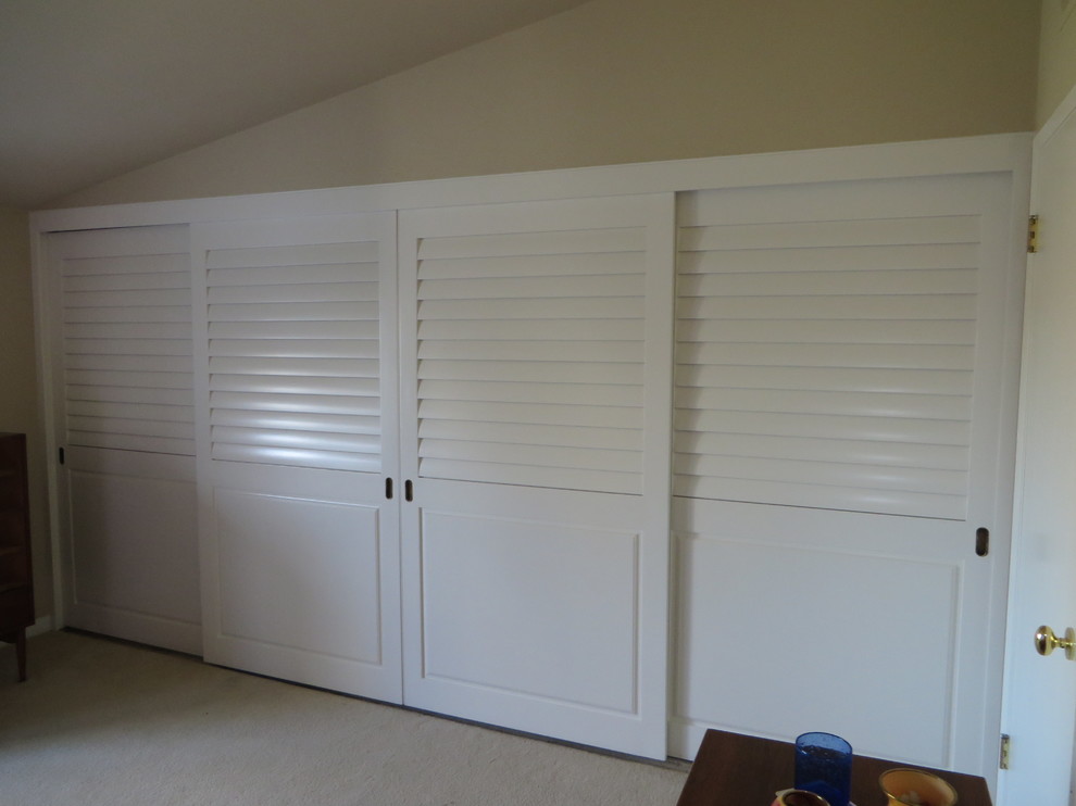 This is an example of a large traditional gender-neutral built-in wardrobe in Los Angeles with carpet and beige floor.