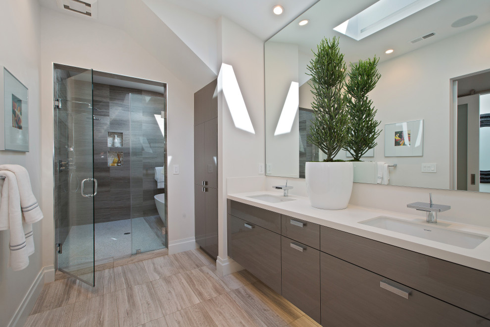 Inspiration for a large modern master wet room bathroom in San Francisco with shaker cabinets, grey cabinets, a freestanding tub, wood-look tile, white walls, light hardwood floors, an undermount sink, brown floor, a hinged shower door, white benchtops, a double vanity, a floating vanity, vaulted and brown tile.
