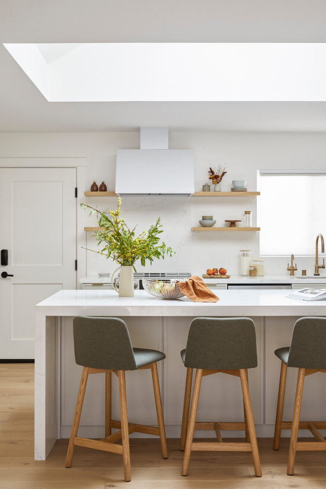 Inspiration for a small scandinavian open plan kitchen in San Francisco with an undermount sink, shaker cabinets, grey cabinets, quartz benchtops, white splashback, engineered quartz splashback, stainless steel appliances, light hardwood floors, with island, brown floor and white benchtop.