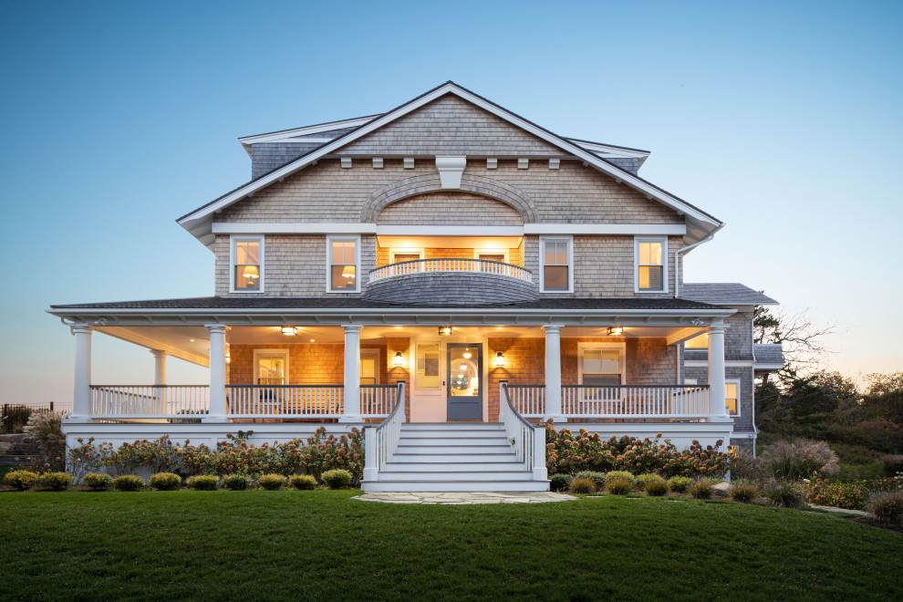 Cette photo montre une grande façade de maison grise bord de mer en bois et bardeaux à trois étages et plus avec un toit à deux pans, un toit en shingle et un toit marron.