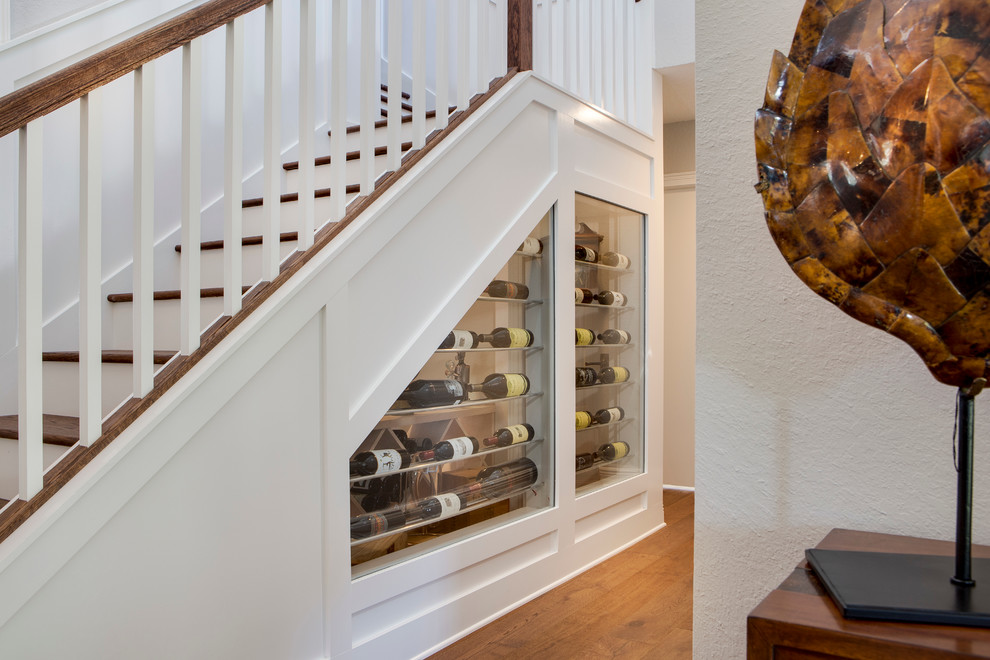 Photo of a mid-sized beach style wine cellar in Orlando with light hardwood floors and display racks.