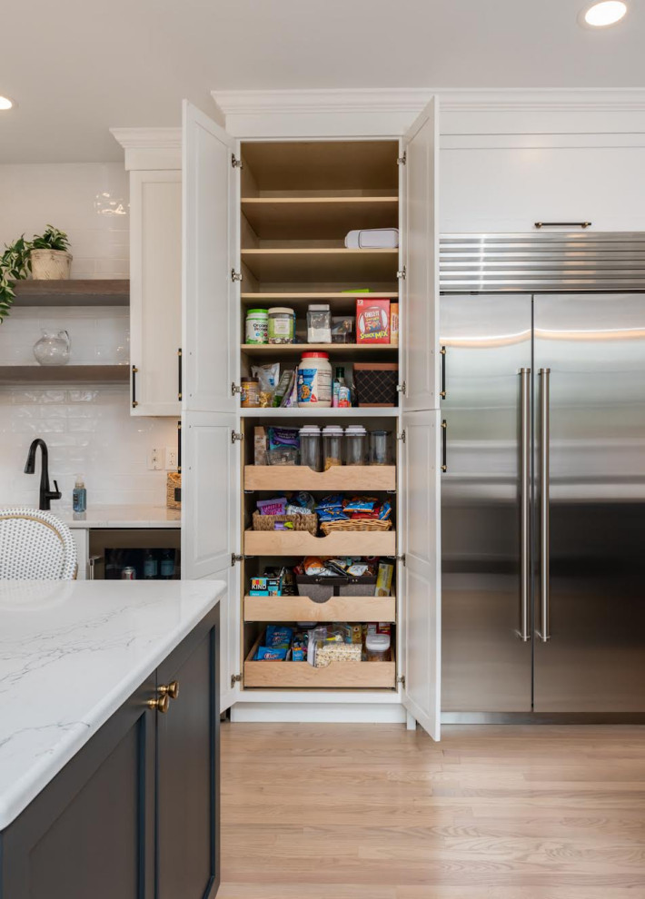 Inspiration for a huge transitional galley light wood floor and gray floor eat-in kitchen remodel with a farmhouse sink, recessed-panel cabinets, white cabinets, quartz countertops, white backsplash, subway tile backsplash, stainless steel appliances, two islands and white countertops