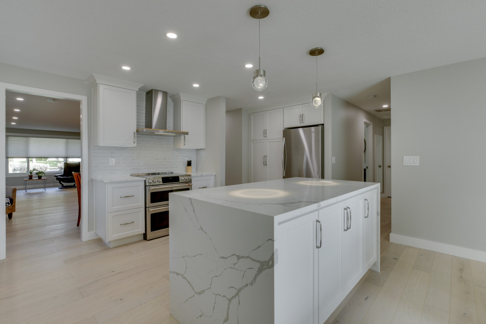 Immagine di una cucina minimalista di medie dimensioni con lavello a vasca singola, ante lisce, ante bianche, top in quarzite, paraspruzzi bianco, parquet chiaro, pavimento beige e top bianco