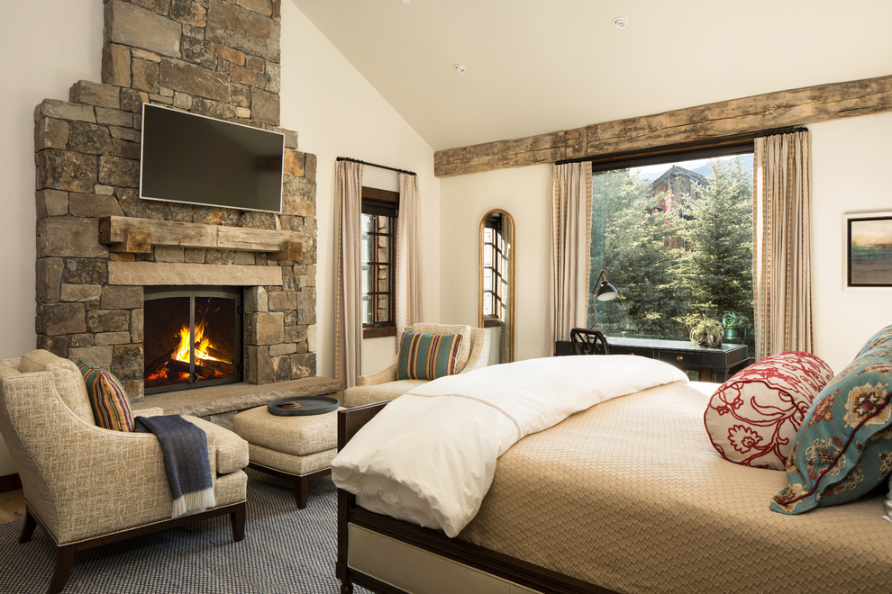 Inspiration for a country master bedroom in Other with white walls, a standard fireplace and a stone fireplace surround.