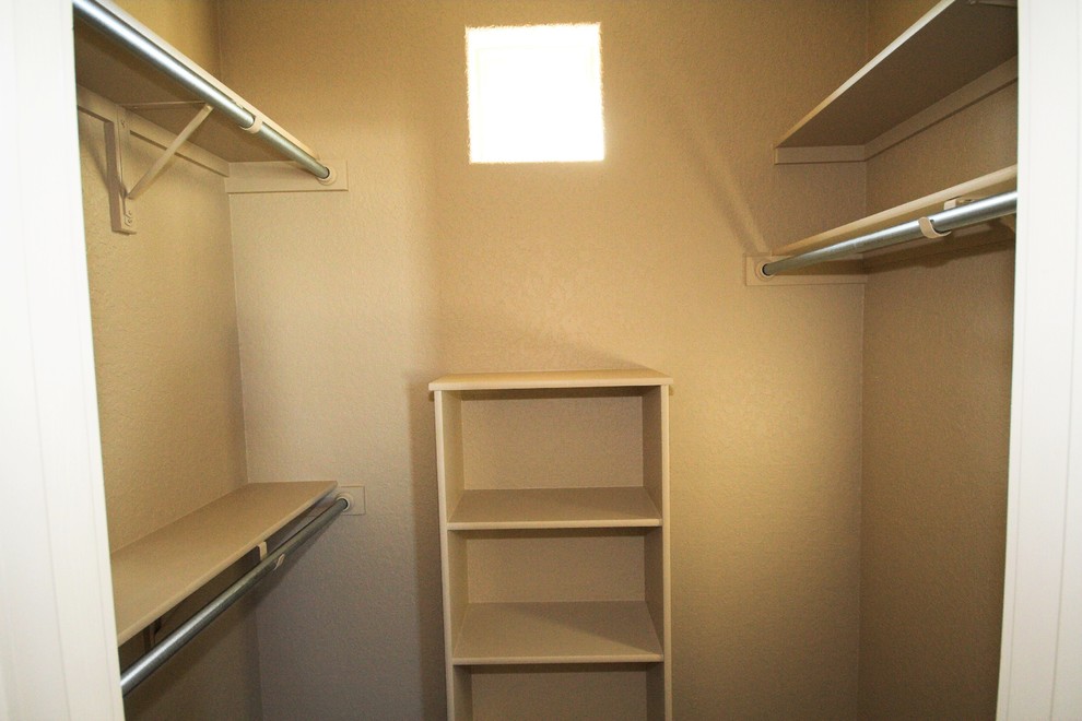 Photo of a mid-sized traditional gender-neutral walk-in wardrobe in Austin with open cabinets, beige cabinets, dark hardwood floors and brown floor.