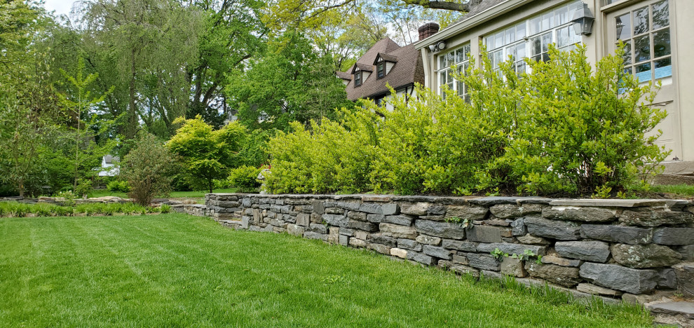 Inspiration for a large side yard full sun formal garden for summer in Philadelphia with a retaining wall.