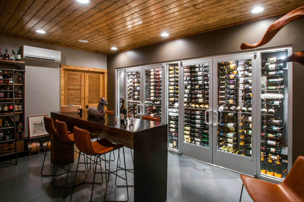 This is an example of a mid-sized contemporary wine cellar in Nashville with laminate floors, storage racks and grey floor.