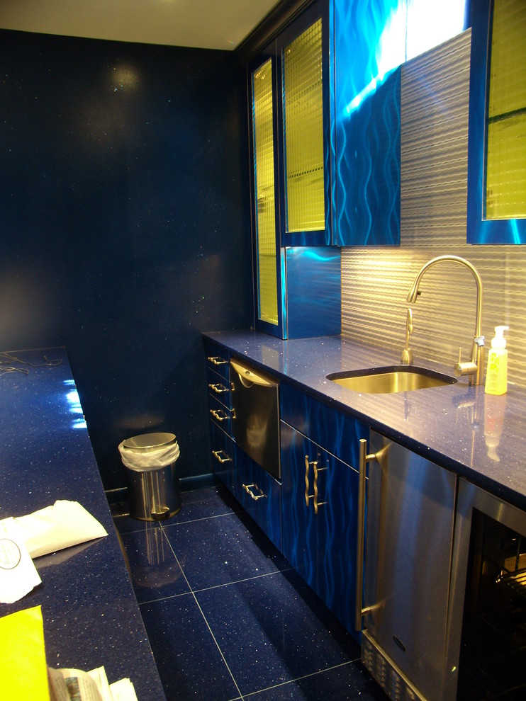 Mid-sized modern galley seated home bar in New York with an undermount sink, flat-panel cabinets, blue cabinets, granite benchtops, grey splashback and blue benchtop.