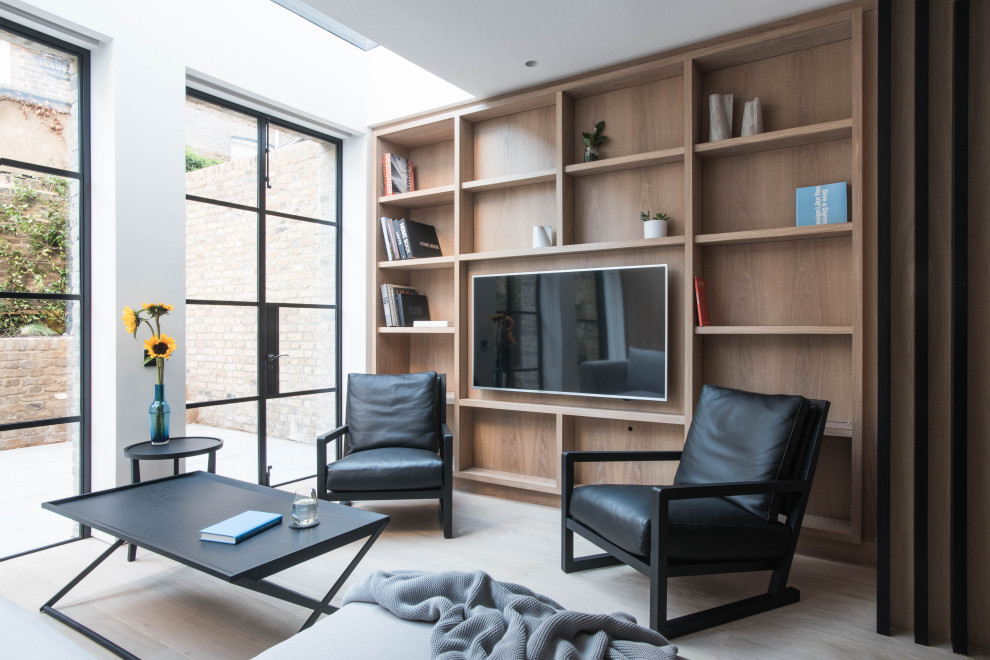 Imagen de sala de estar con biblioteca abierta nórdica grande con pared multimedia y madera