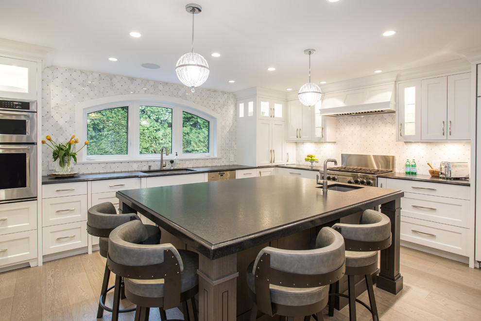 Inspiration for a large transitional l-shaped medium tone wood floor and beige floor eat-in kitchen remodel in Vancouver with an undermount sink, shaker cabinets, white cabinets, granite countertops, gray backsplash, marble backsplash, stainless steel appliances, an island and black countertops