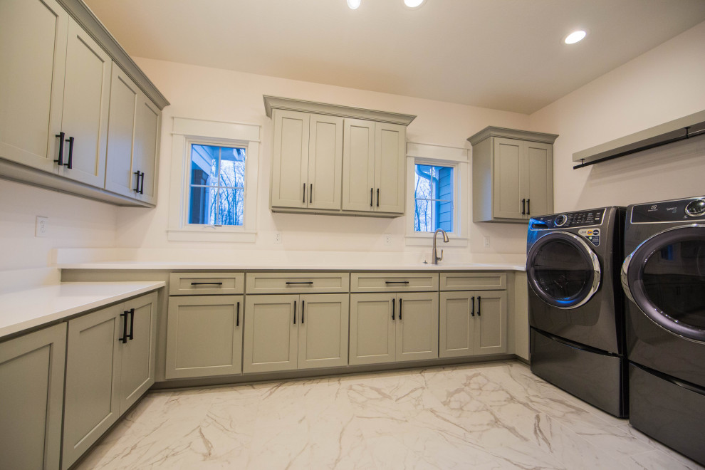 Inspiration for a large classic u-shaped separated utility room in Indianapolis with a submerged sink, recessed-panel cabinets, green cabinets, quartz worktops, white walls, marble flooring, a side by side washer and dryer, white floors and white worktops.