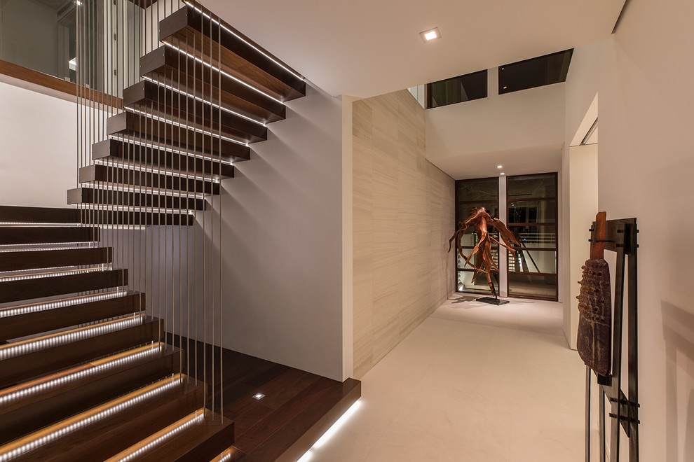 Expansive beach style wood floating staircase in Miami with open risers and mixed railing.