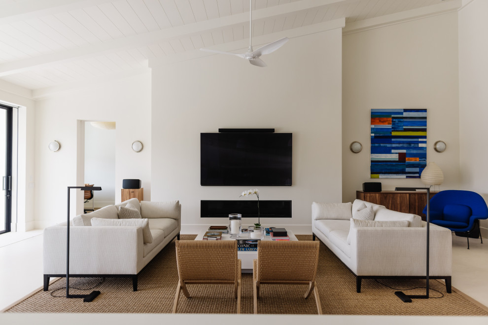 Immagine di un soggiorno stile marinaro con pareti beige, TV a parete, pavimento beige e soffitto a volta