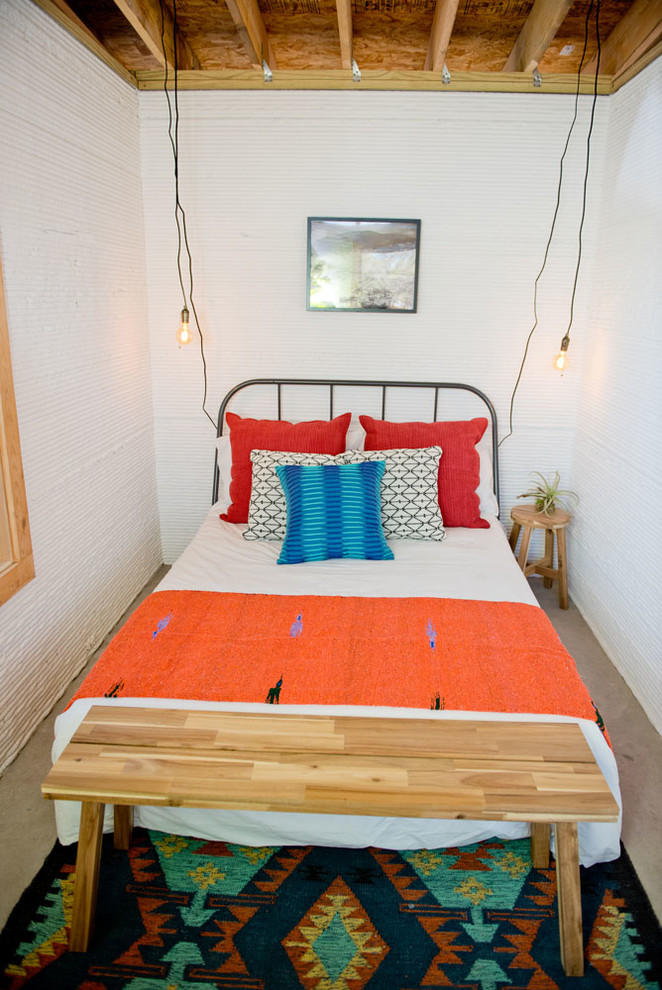 Photo of a mid-sized industrial bedroom in Austin with white walls and no fireplace.