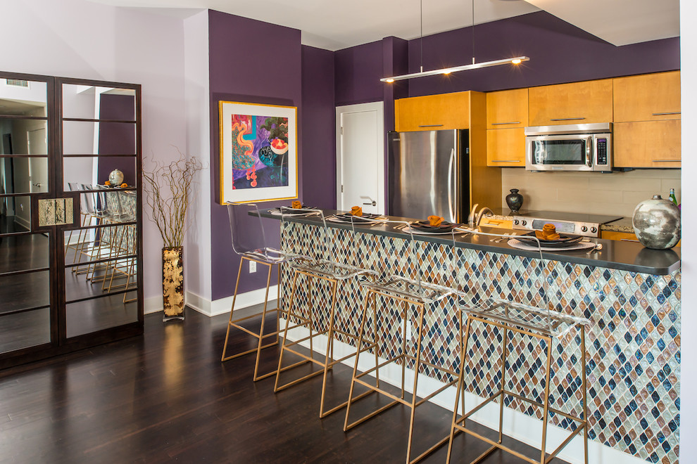 This is an example of a contemporary galley kitchen in Austin with flat-panel cabinets, medium wood cabinets, beige splashback, dark hardwood floors, a peninsula and stainless steel appliances.