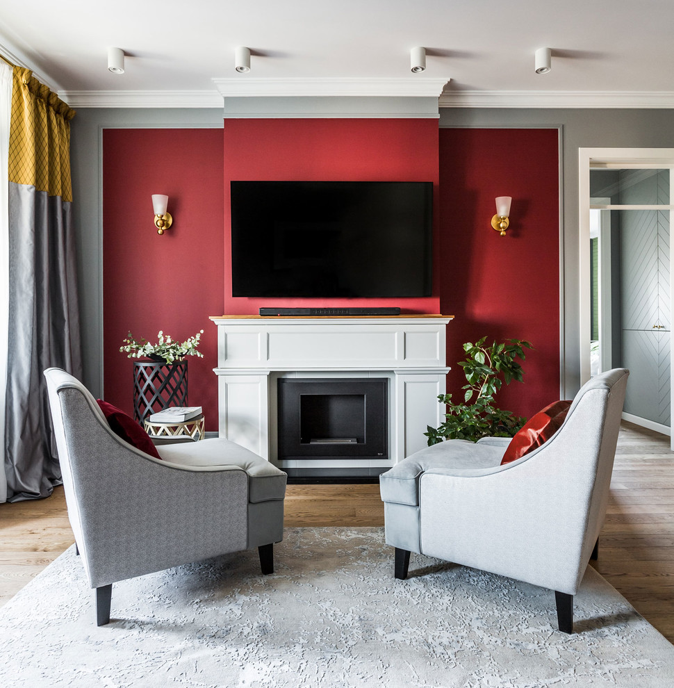 Inspiration for a transitional living room in Toronto with red walls, medium hardwood floors, a standard fireplace, a wall-mounted tv and brown floor.