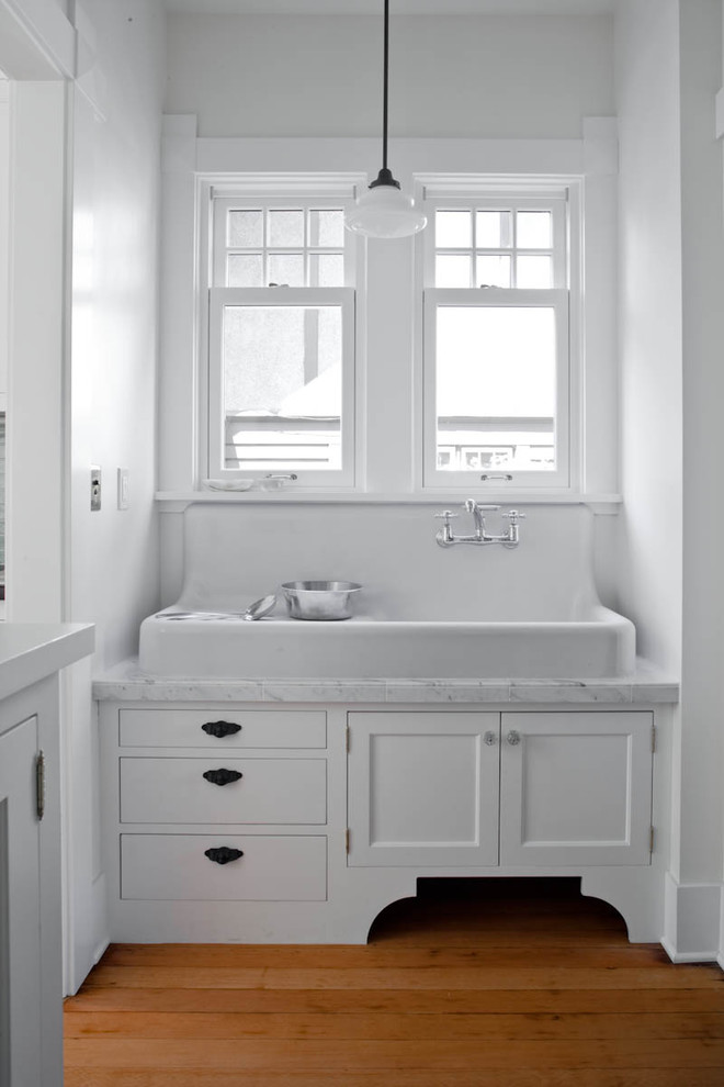 Photo of a traditional kitchen in Seattle with a farmhouse sink, recessed-panel cabinets and white cabinets.