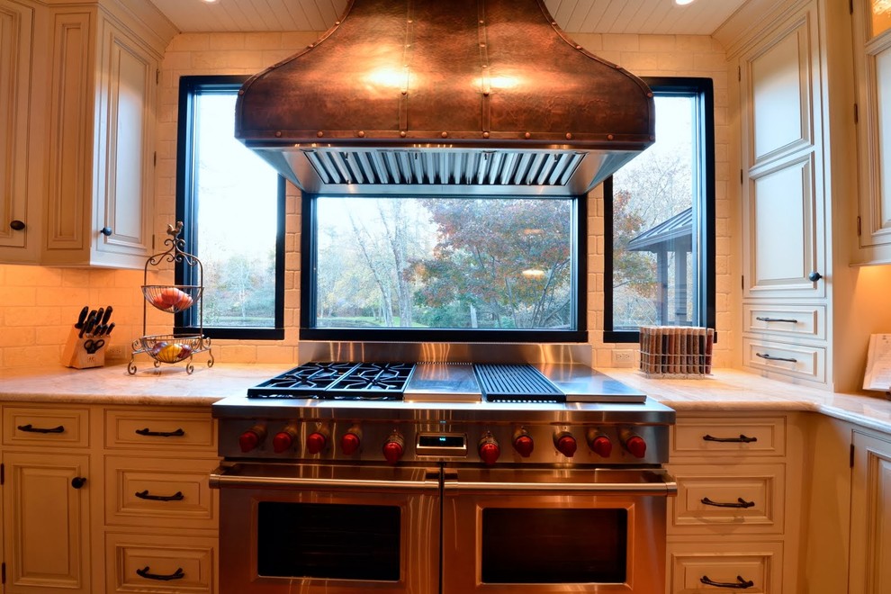 Inspiration for a mid-sized transitional u-shaped medium tone wood floor eat-in kitchen remodel with an undermount sink, raised-panel cabinets, white cabinets, marble countertops, white backsplash, brick backsplash, paneled appliances and an island
