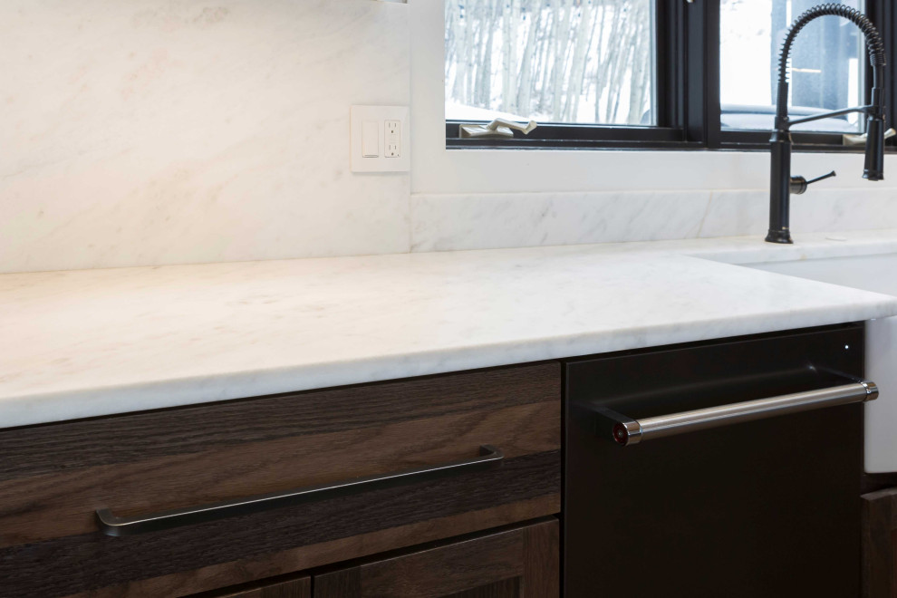 Huge transitional single-wall dark wood floor, brown floor and shiplap ceiling open concept kitchen photo in Denver with a farmhouse sink, shaker cabinets, dark wood cabinets, marble countertops, paneled appliances, an island and white countertops