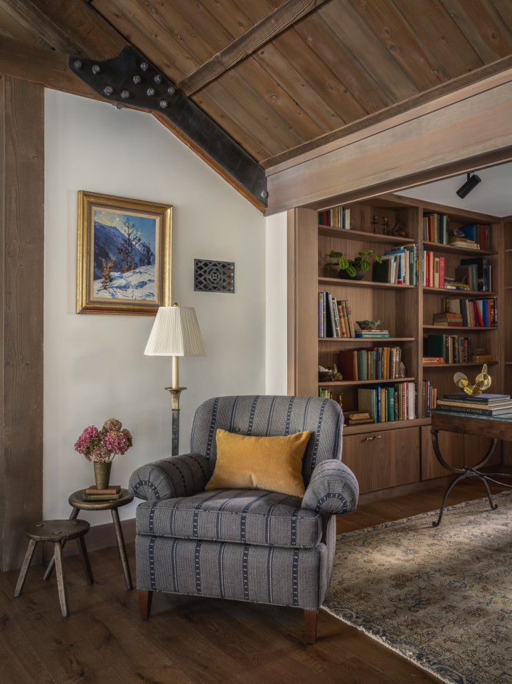 Inspiration for a rustic open concept medium tone wood floor, brown floor and exposed beam living room library remodel with white walls, a standard fireplace and a stone fireplace