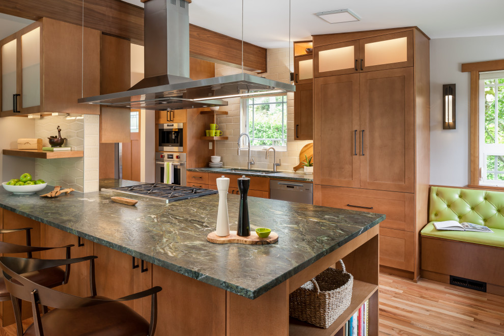 Design ideas for a transitional galley kitchen in Seattle with an undermount sink, shaker cabinets, medium wood cabinets, granite benchtops, white splashback, subway tile splashback, stainless steel appliances, a peninsula, green benchtop, medium hardwood floors and vaulted.