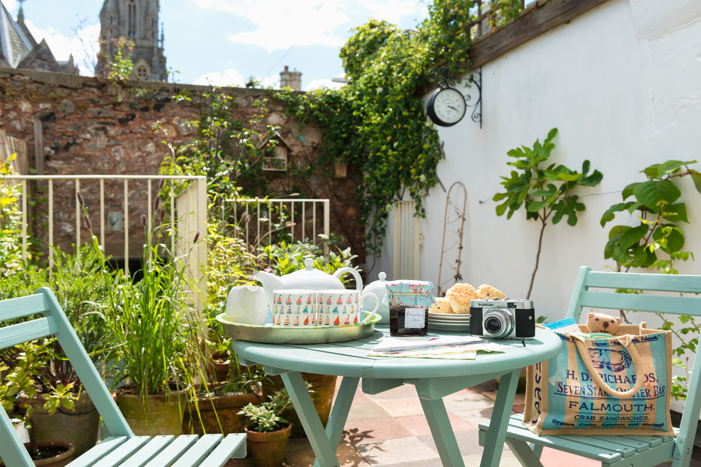 Design ideas for a small eclectic patio in Devon with a container garden and tile.