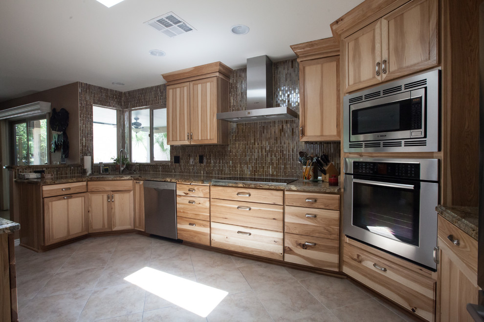 Large transitional galley ceramic tile enclosed kitchen photo in Phoenix with an undermount sink, recessed-panel cabinets, light wood cabinets, granite countertops, brown backsplash, glass tile backsplash and stainless steel appliances